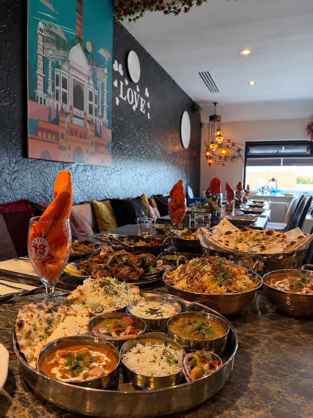 A table laid with biryani, curries, naan and a thali in the King's dining room