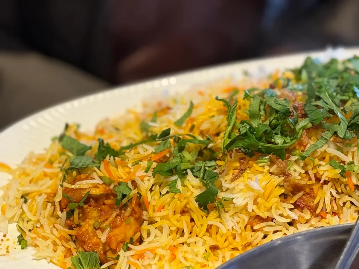 Golden saffron basmati biryani topped with fresh mint, coriander and fried onions